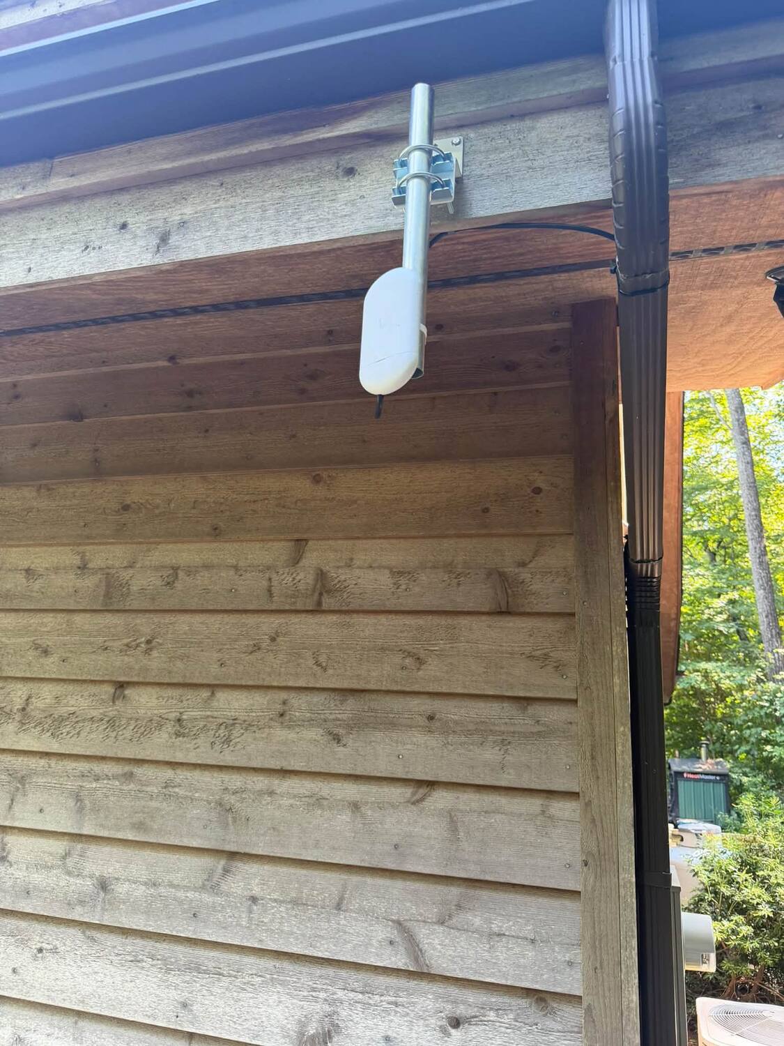 Point-to-point wireless bridge radio mounted at a home eave