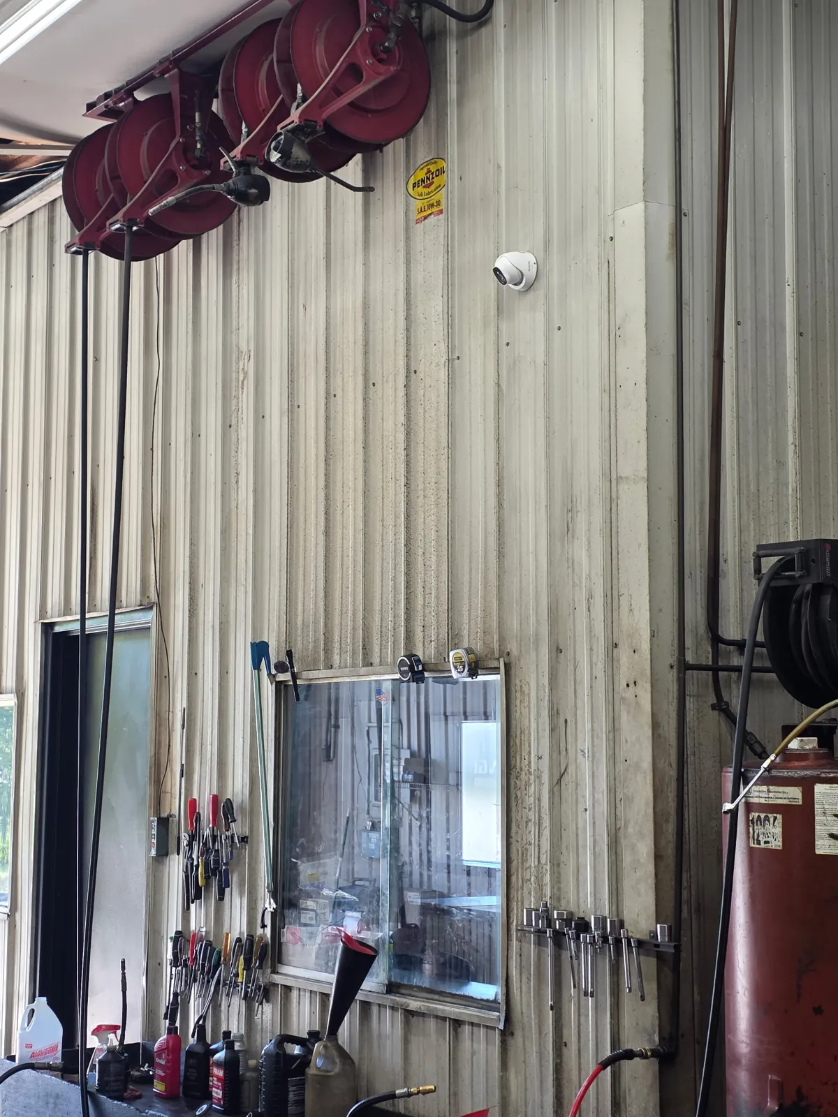 Dome security camera installed above the service bay workbench at Redline Tire & Lube