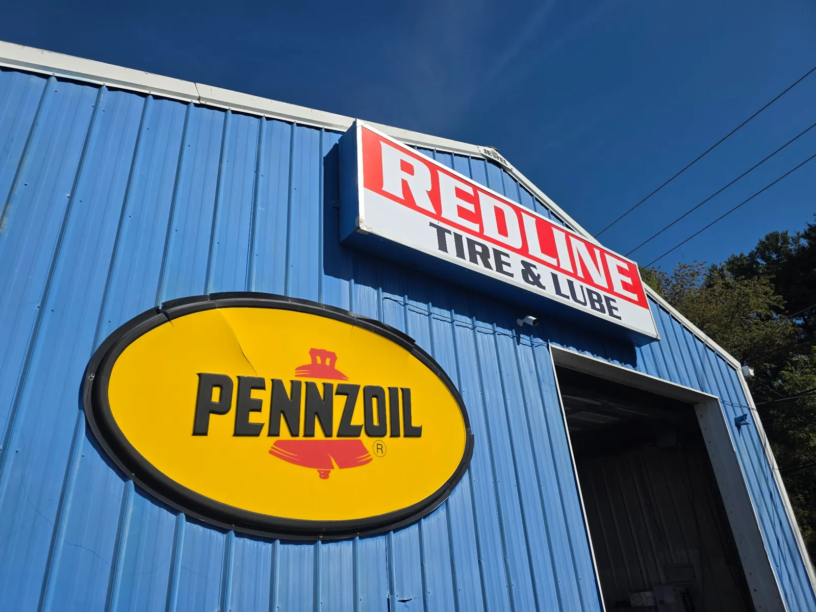 Commercial security camera installation at Redline Tire & Lube in Christiansburg, VA, with the camera mounted below the business sign